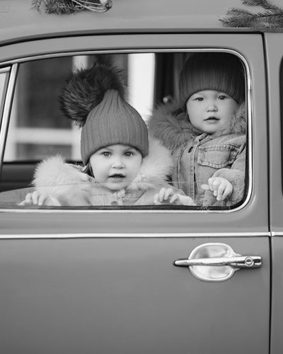 two-cute-little-kids-winter-clothes-peeking-out-window-bright-red-car